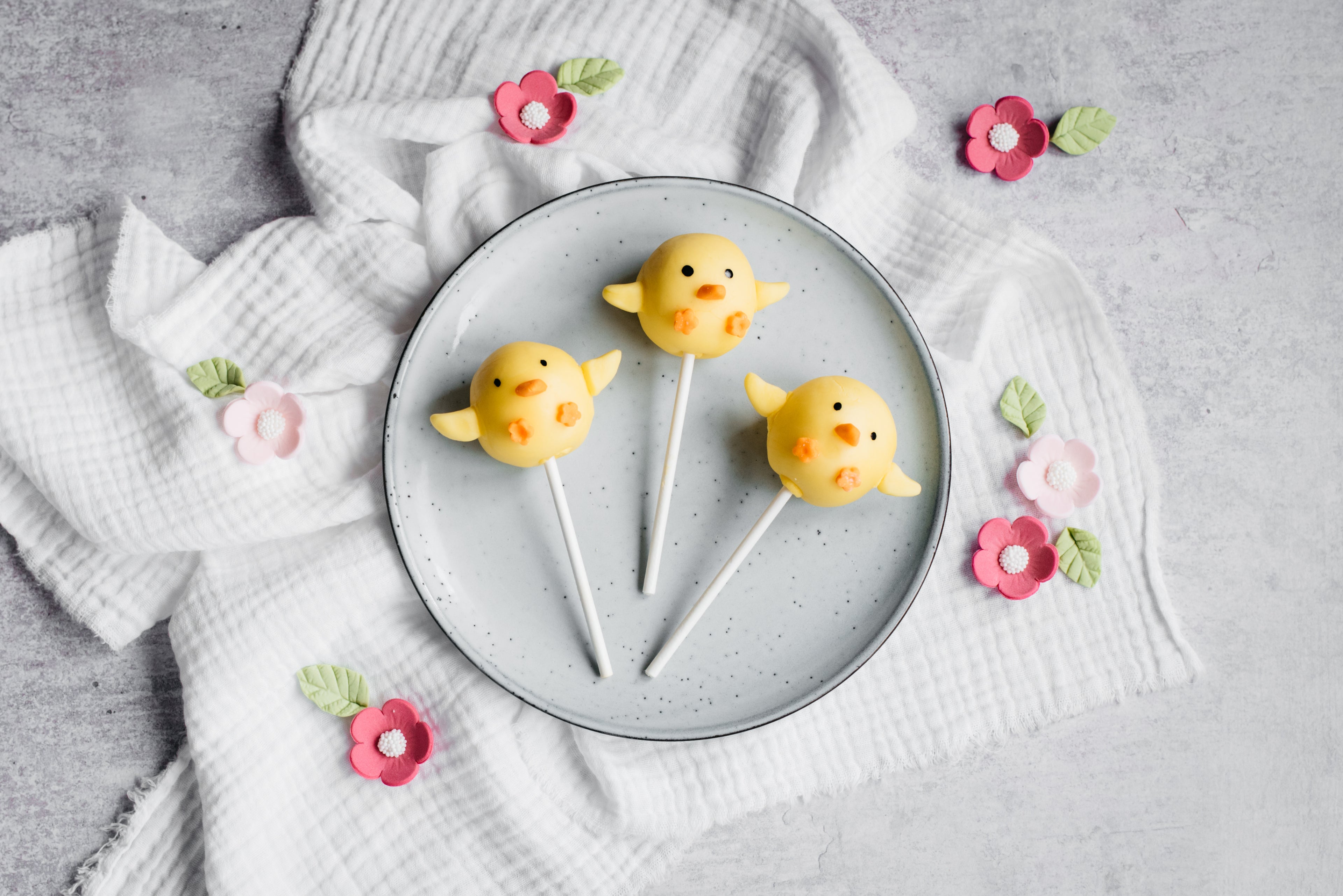 three chick cake pops covered in yellow chocolate