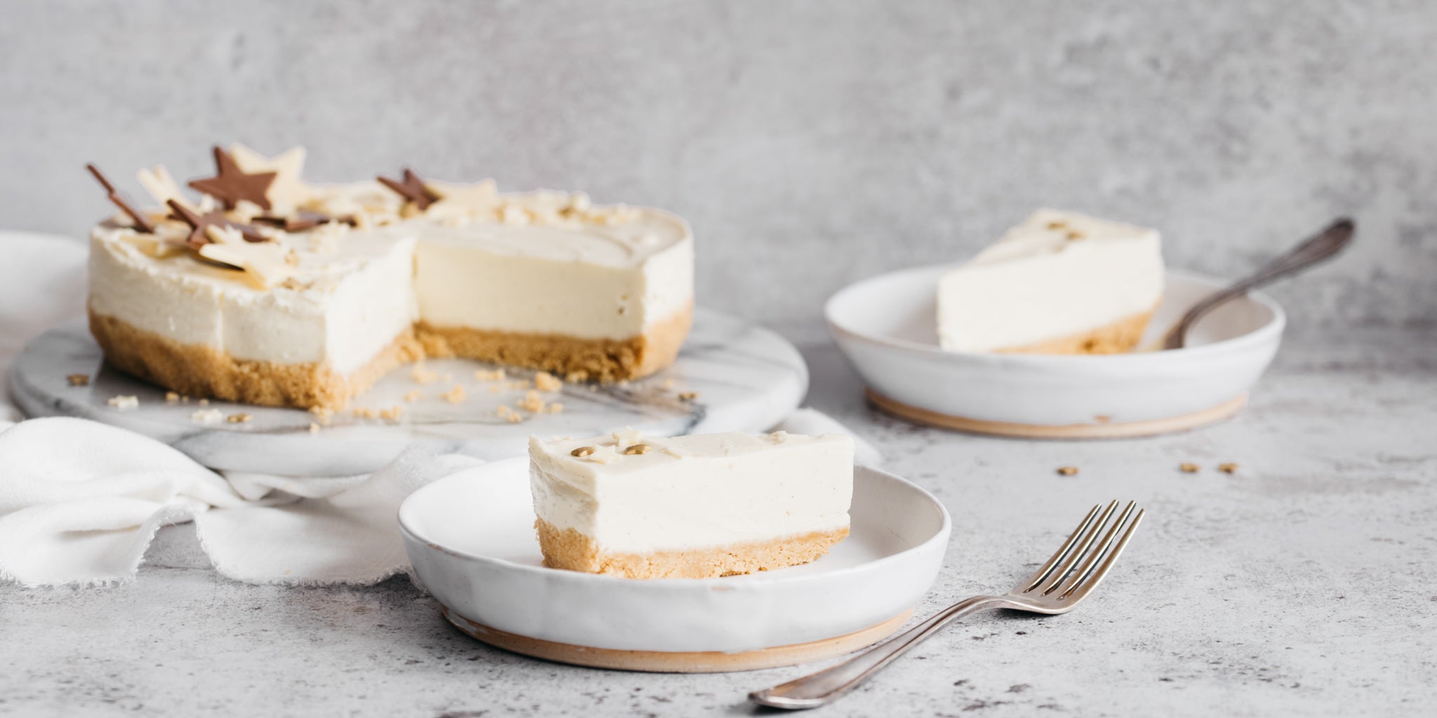 Cheesecake with slices removed and in bowls with forks