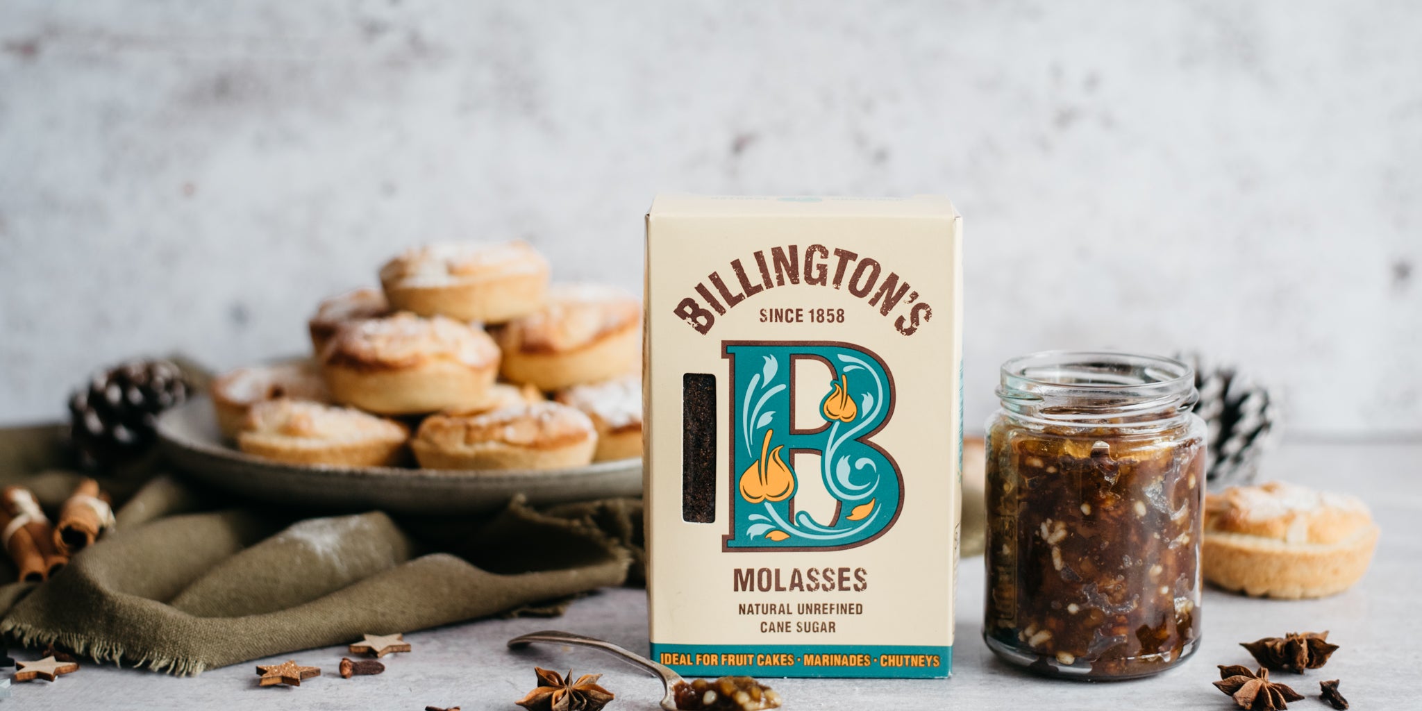 Frangipane Mince Pies on a plate, with a box of Billington's Molasses in the foreground, next to a jar of luxury mince meat