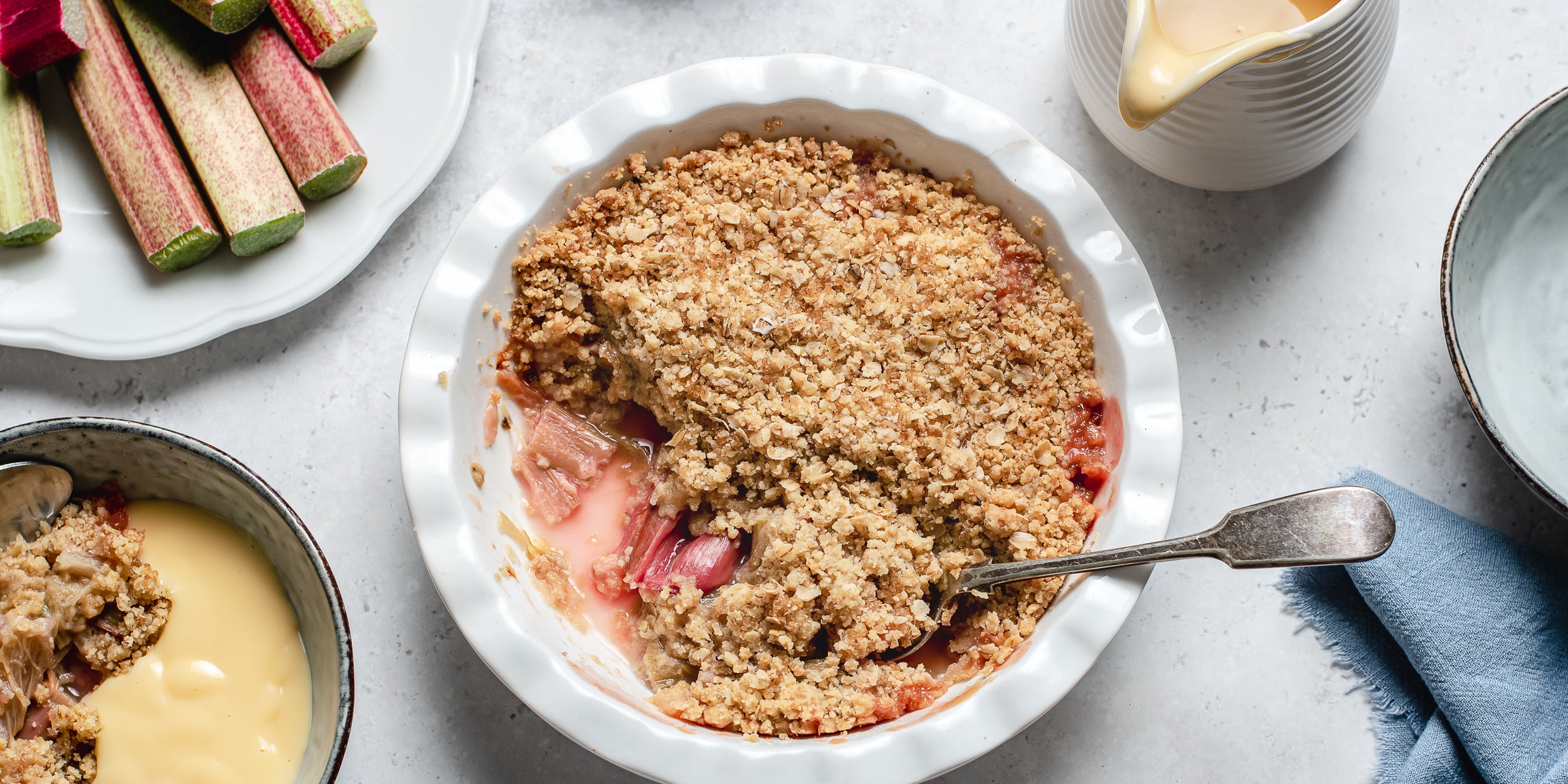 Close up on Rhubarb Crumble freshly baked with a spoon dipping into to serve