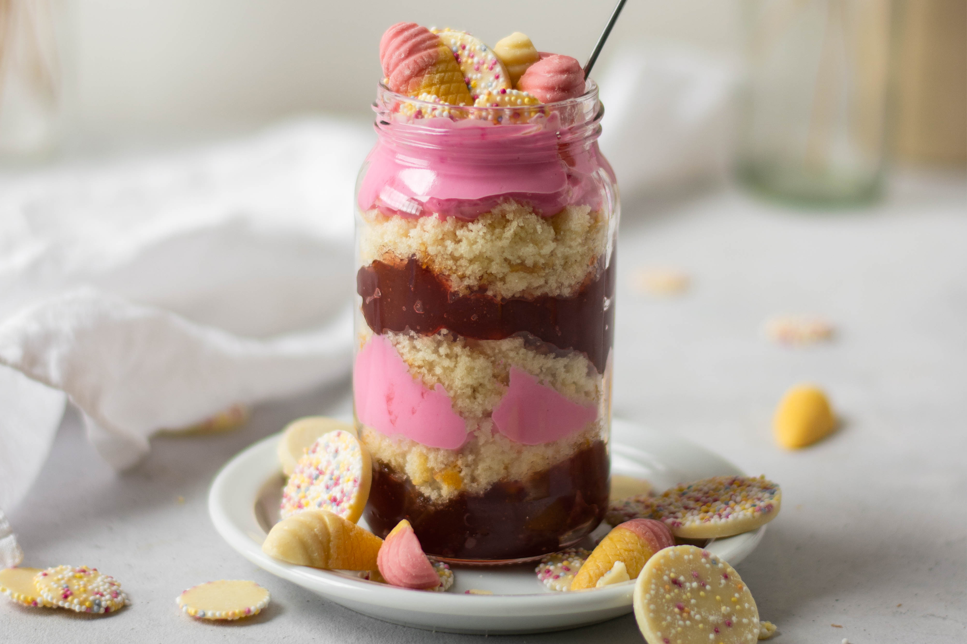 Close up of Pick'n'Mix Cake Jar with handfuls of sweeties and spoon