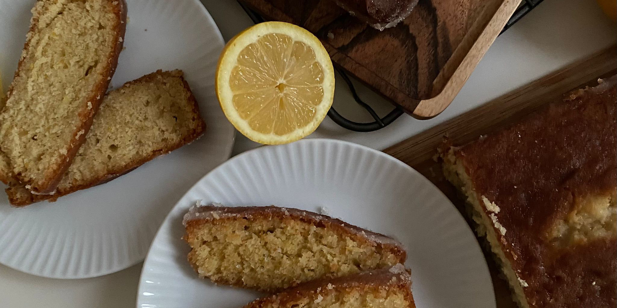 Slices of Mary Berry's and Nigella's lemon drizzle cakes on white plates