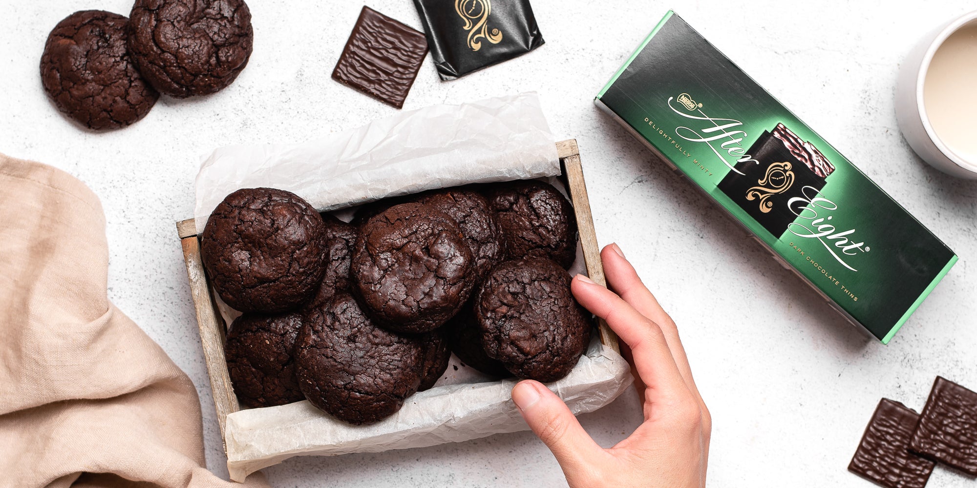 Chocolate Brownie Cookies stuffed with After Eight chocolate mints with a hand reaching for one