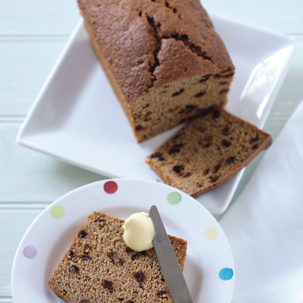 Spreading butter on slices of bara brith