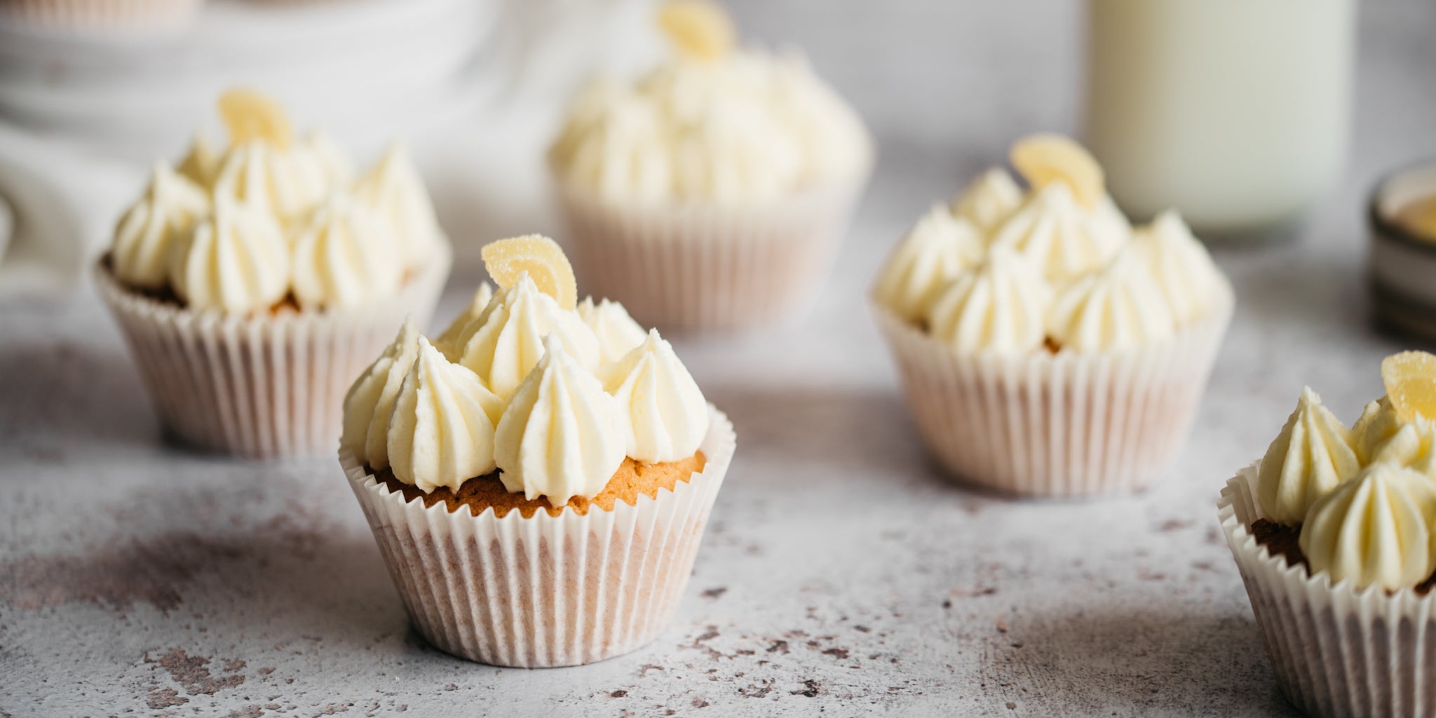 Close up of Lemon Cupcakes delicately piped with lemon buttercream and garnished with lemon