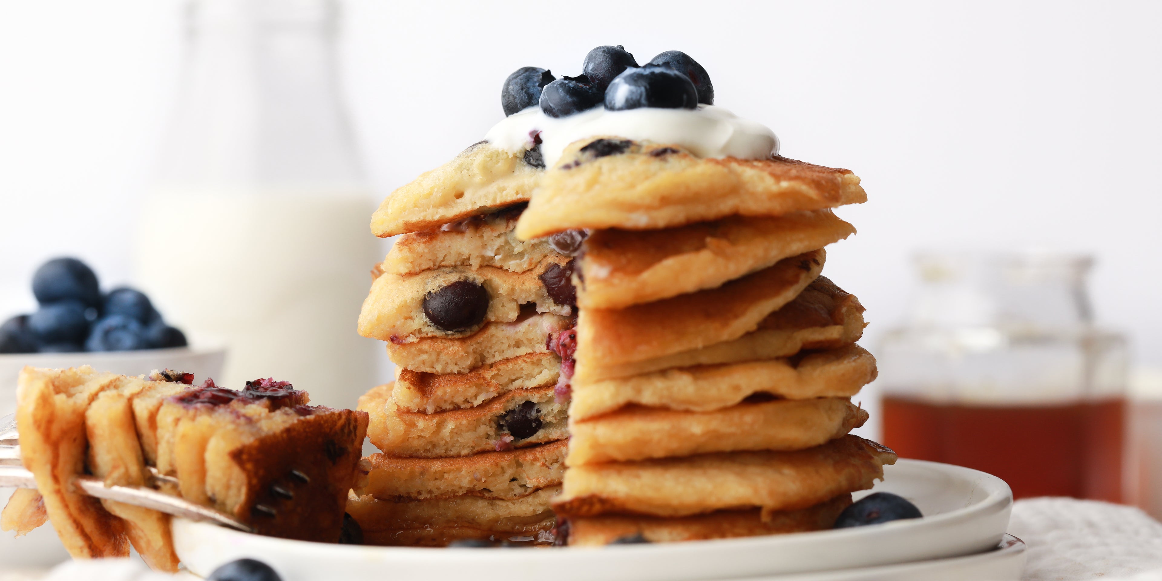 Stack of blueberry pancakes with a chunk removed