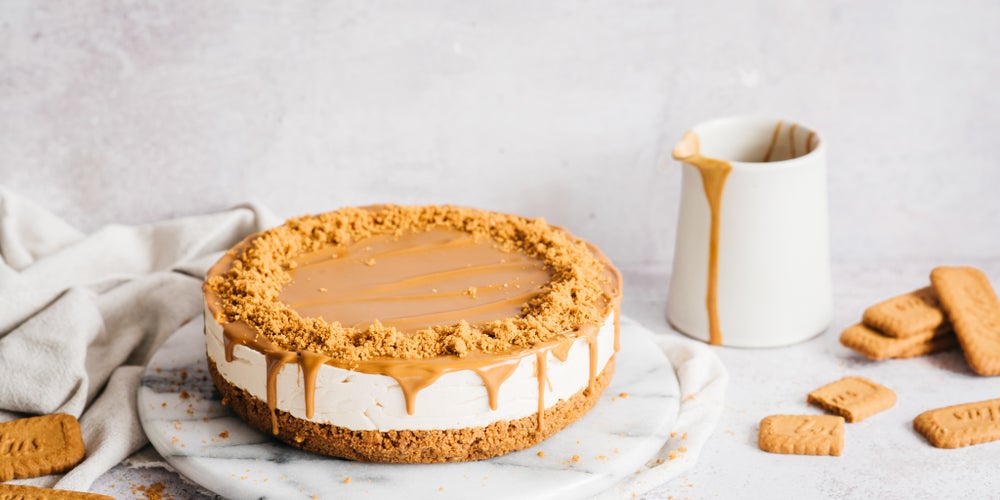 Biscoff cheesecake beside a jug with drip pouring down
