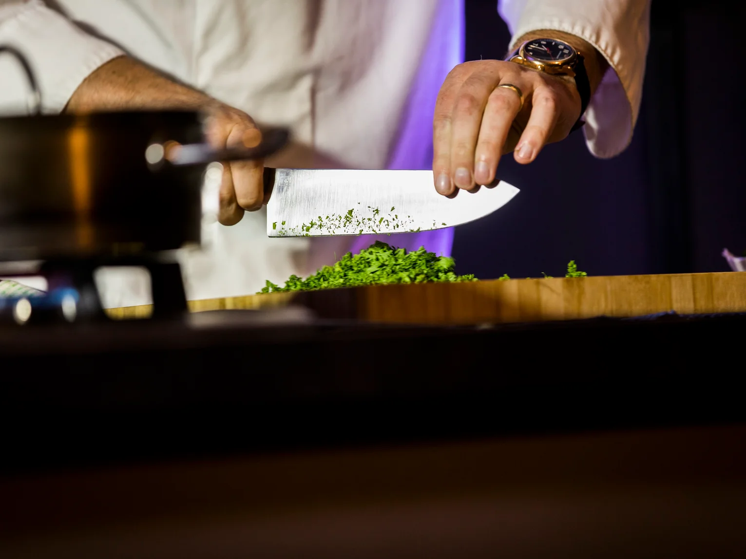 Kitchen staff setting up a breakfast buffet service, with a chef working at an open kitchen pass