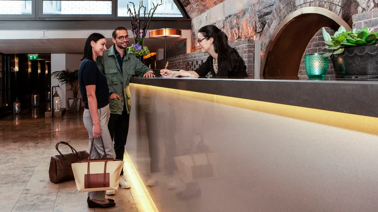 A group of people standing at a reception desk