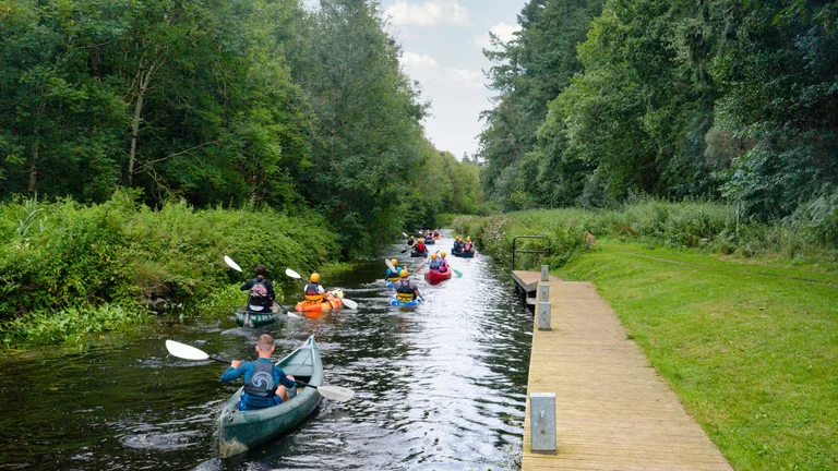 A group of people in canoes on a river