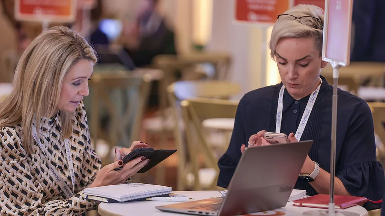 A group of women sitting at a table looking at a laptop