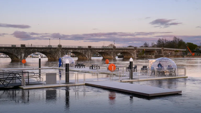 A floating outdoor swimming pool and a bridge in the background