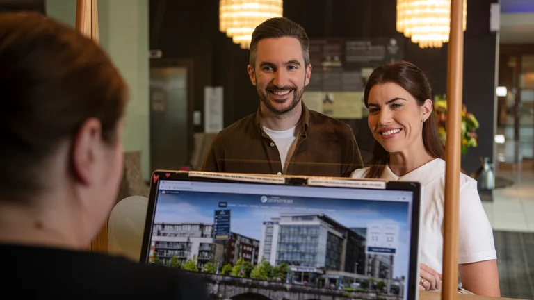 A man and woman looking at a laptop