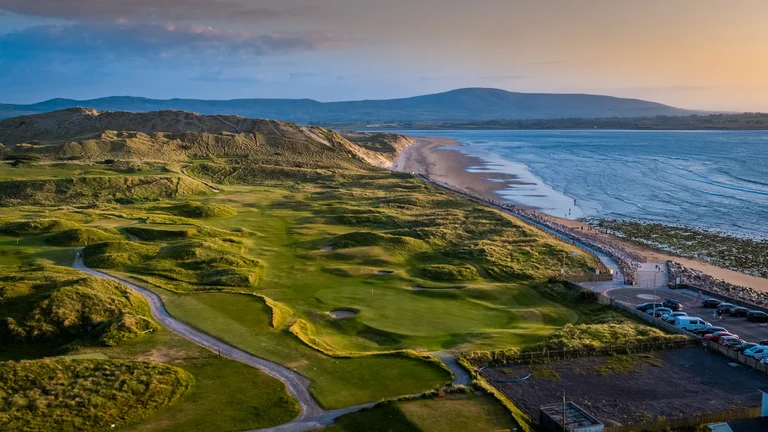 A golf course with a beach and water