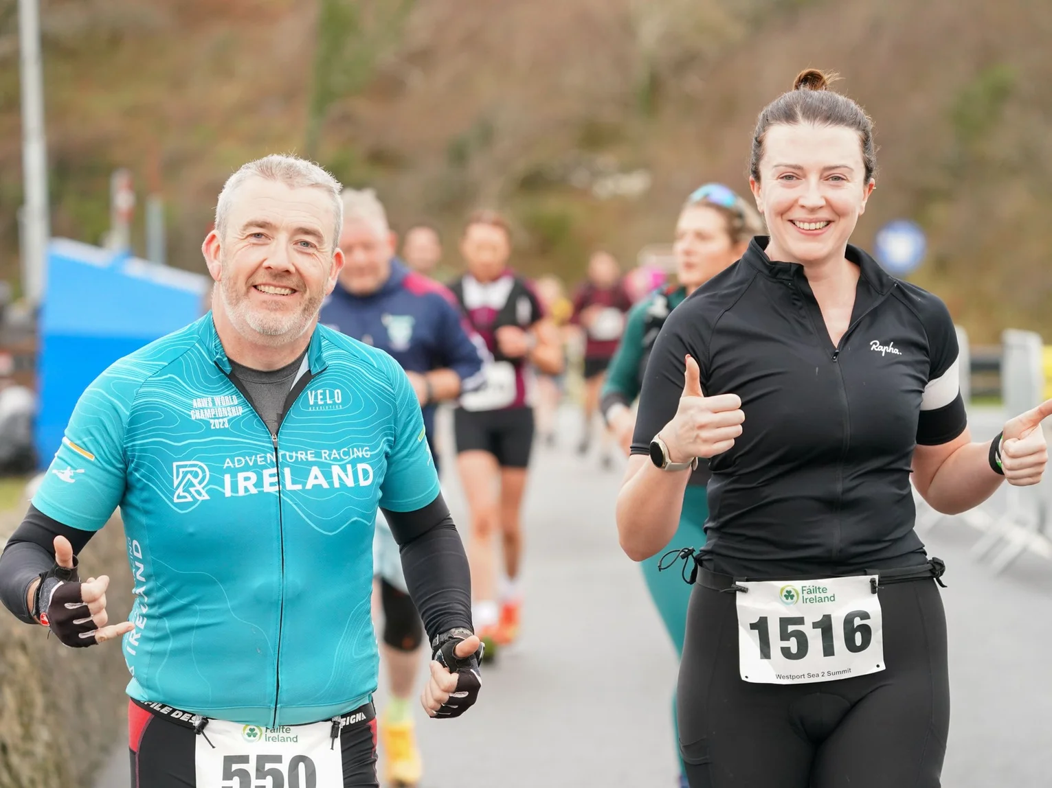 Two participants smiling during an outdoor walking or running event.