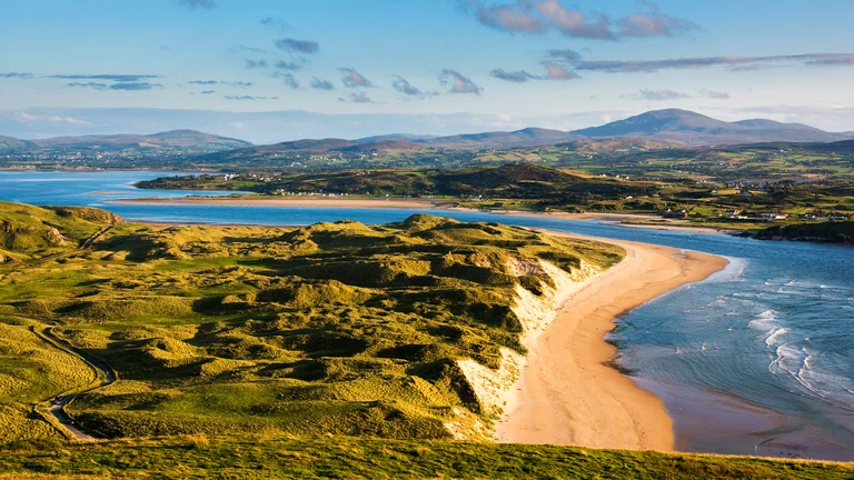 A beach with a body of water and hills