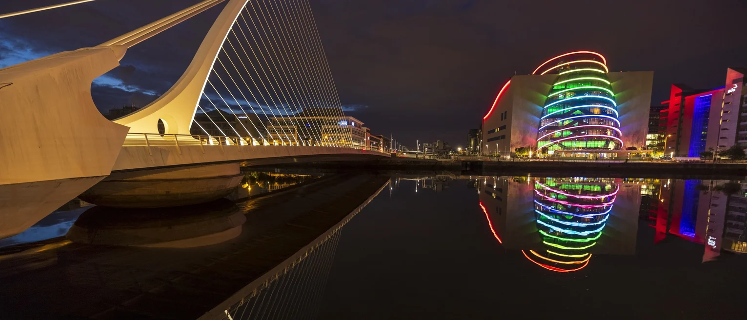 A photo taken at night time showing a bridge and the National Convention Centre in Dublin