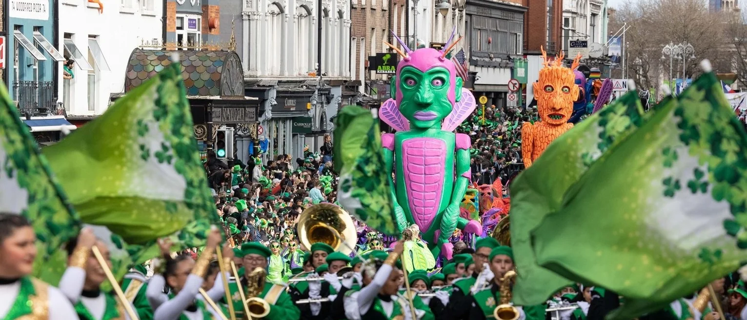 Floats and flag bearers march in the Saint Patricks day parade.