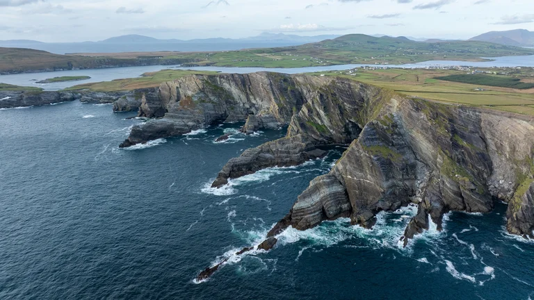 A large rocky cliff above water