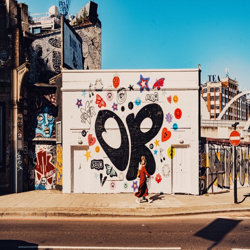 Woman walking past a mural