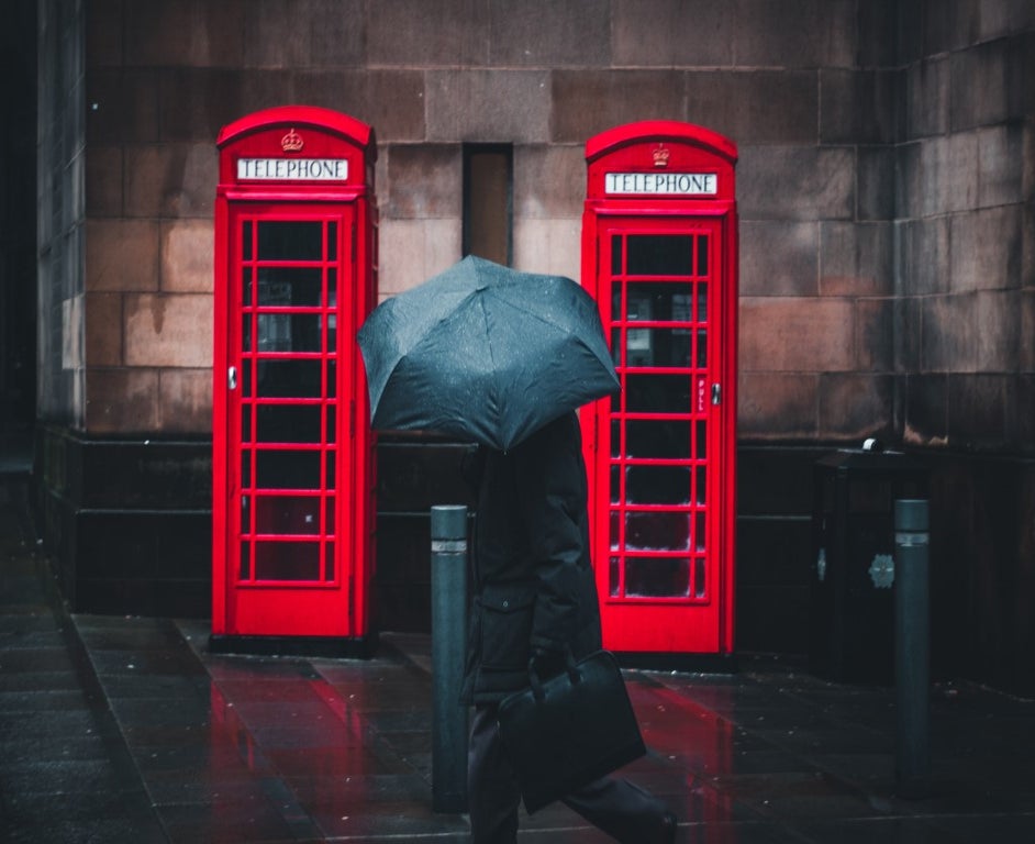 Person walking in rain with umbrella
