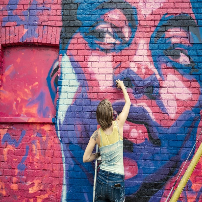 Woman painting on a wall