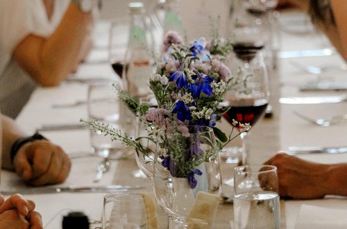 Galadinner: im Vordergrund Tischdekoration und im Hintergrund mehrere Personen Galadinner: im Vordergrund Tischdekoration und im Hintergrund mehrere Personen