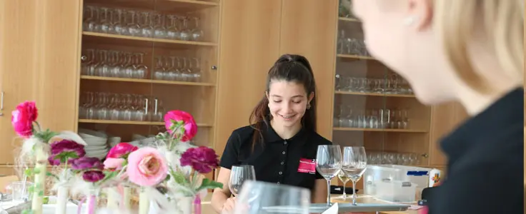 Schülerin beim Eindecken eines Tisches Schülerin beim Eindecken eines Tisches