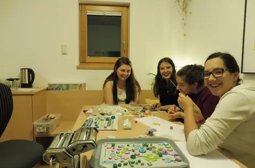 Mädchen stellen Schmuck aus Fimo her. Mädchen stellen Schmuck aus Fimo her.