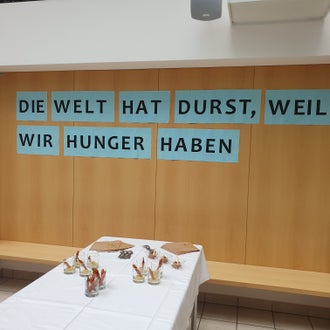 Schriftzug: "Die Welt hat Durst, weil wir Hunger haben". Schriftzug: "Die Welt hat Durst, weil wir Hunger haben".