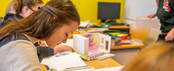 Schülerinnen beim Modellbau. Schülerin zeichnet eine Raumskizze. Schülerinnen beim Modellbau. Schülerin zeichnet eine Raumskizze.