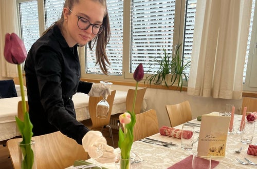 Schülerin beim Aufdecken der Tische Schülerin beim Aufdecken der Tische