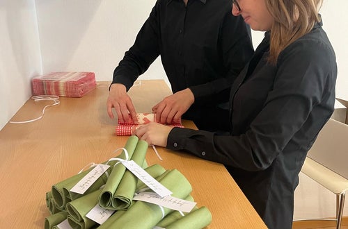 Schülerinnen bei der Serviettenfaltung Schülerinnen bei der Serviettenfaltung