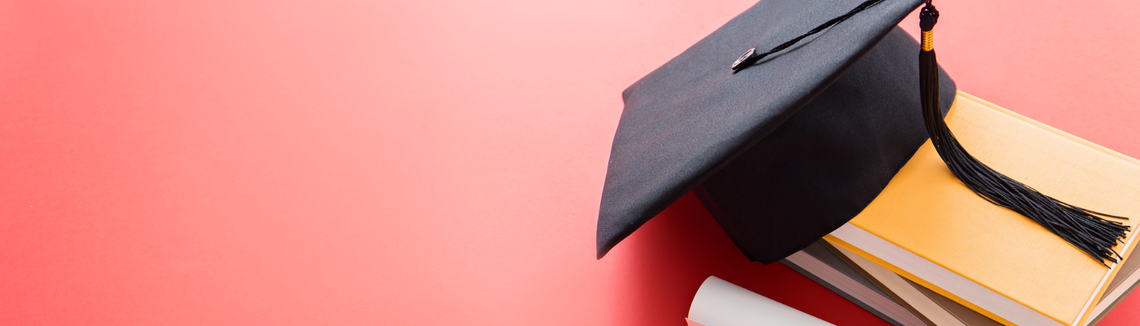 czapka absolwenta studiuów, uniwersytetu Colonnade oraz książki i dyplom