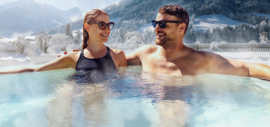 Muž so ženou v bazéne na horách