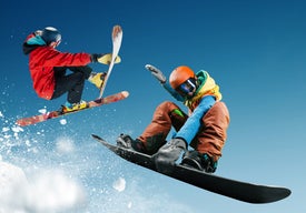 Сноубордист и скиор в екстремен скок