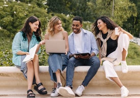 A group of young people sitting on a stone ledge