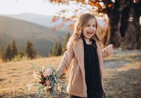 Dívka držící kytici květin v podzimní přírodě
