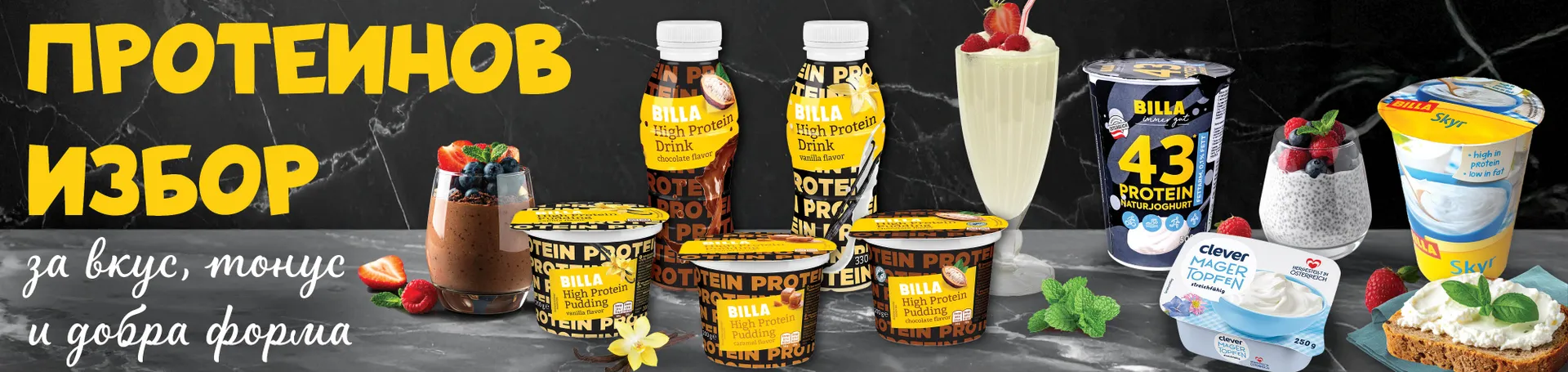 Банер с различни протеинови продукти от собствените марки на BILLA – протеинови пудинги, протеинови напитки, кисело мляко с високо съдържание на протеин, извара и Skyr. Заглавие: ‘Протеинов избор’. Подтекст: ‘За вкус, тонус и добра форма’. Продуктите са показани заедно с пресни плодове, ядки и десерти като идеи за сервиране.