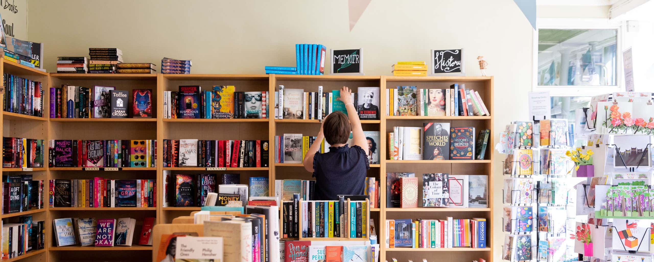 person putting book on shelf