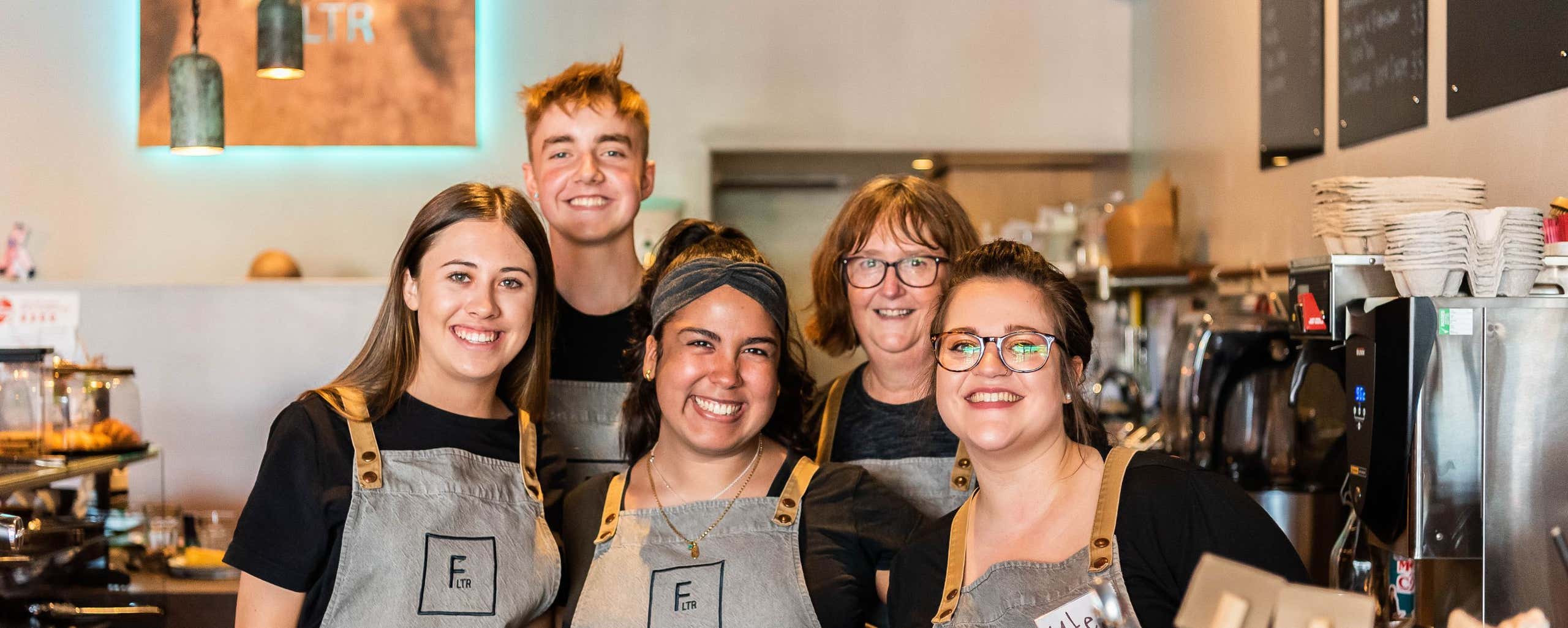 team photo behind the counter of coffee shop