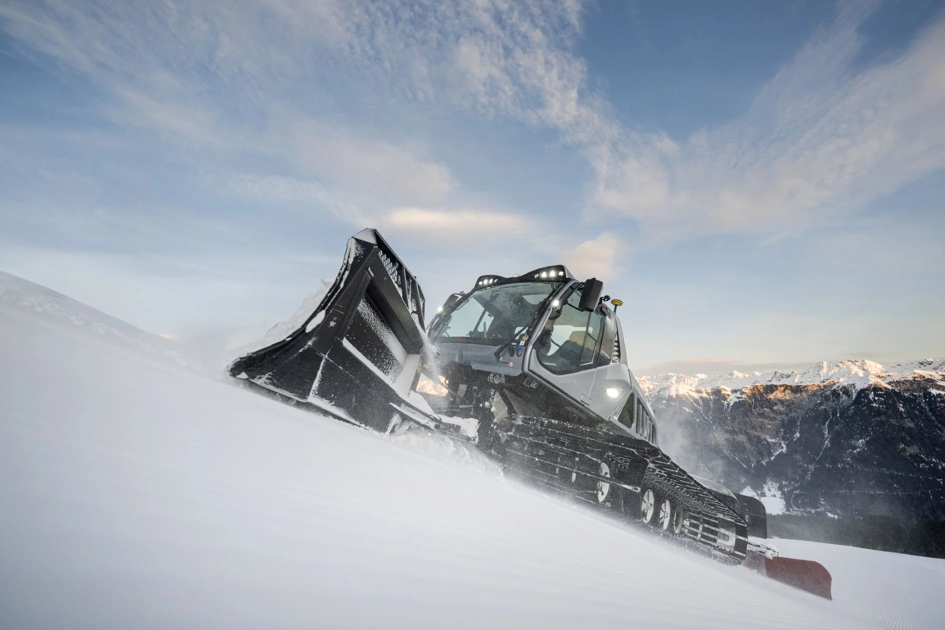Snow groomer in action on a ski slope