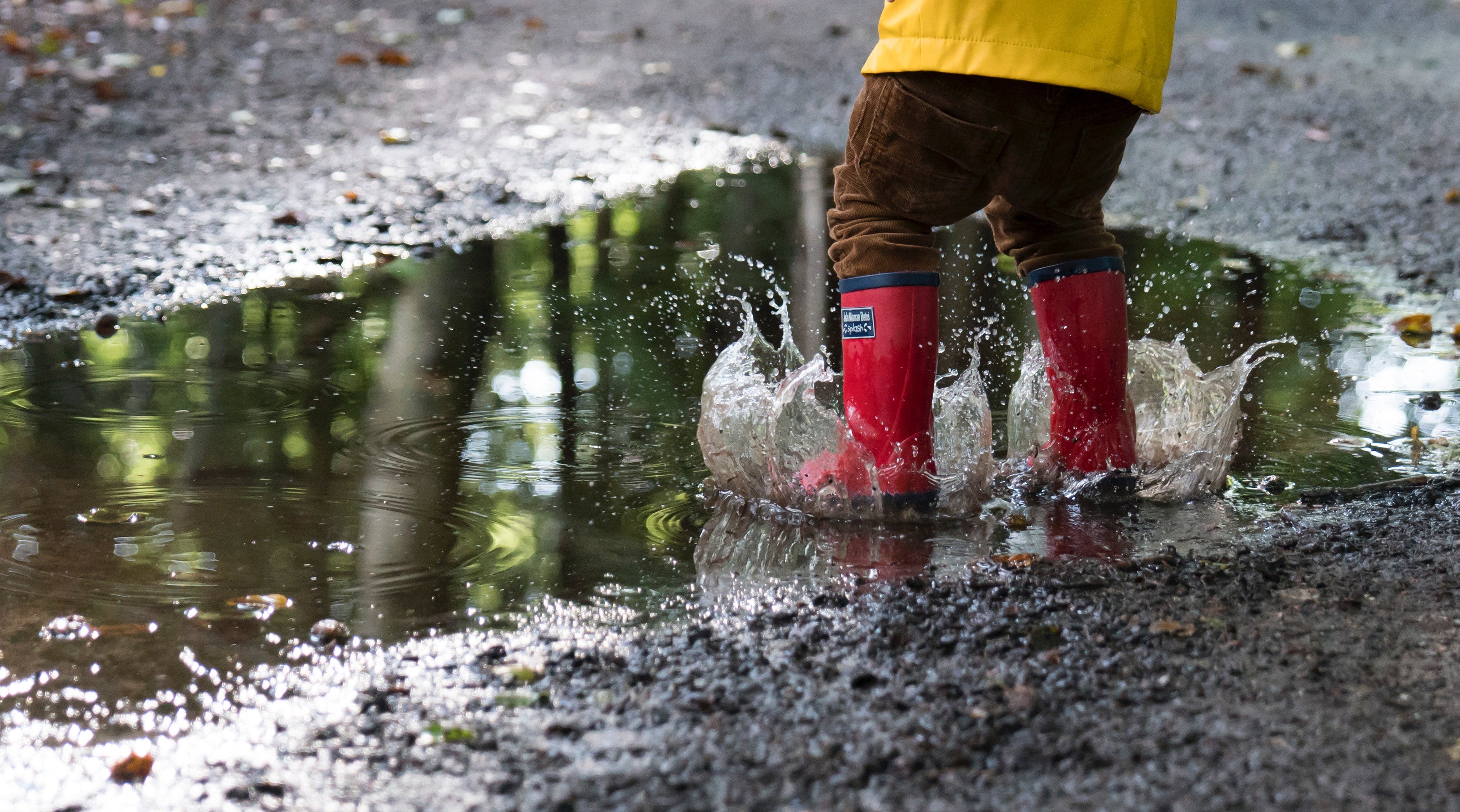 Child jumping in puddles