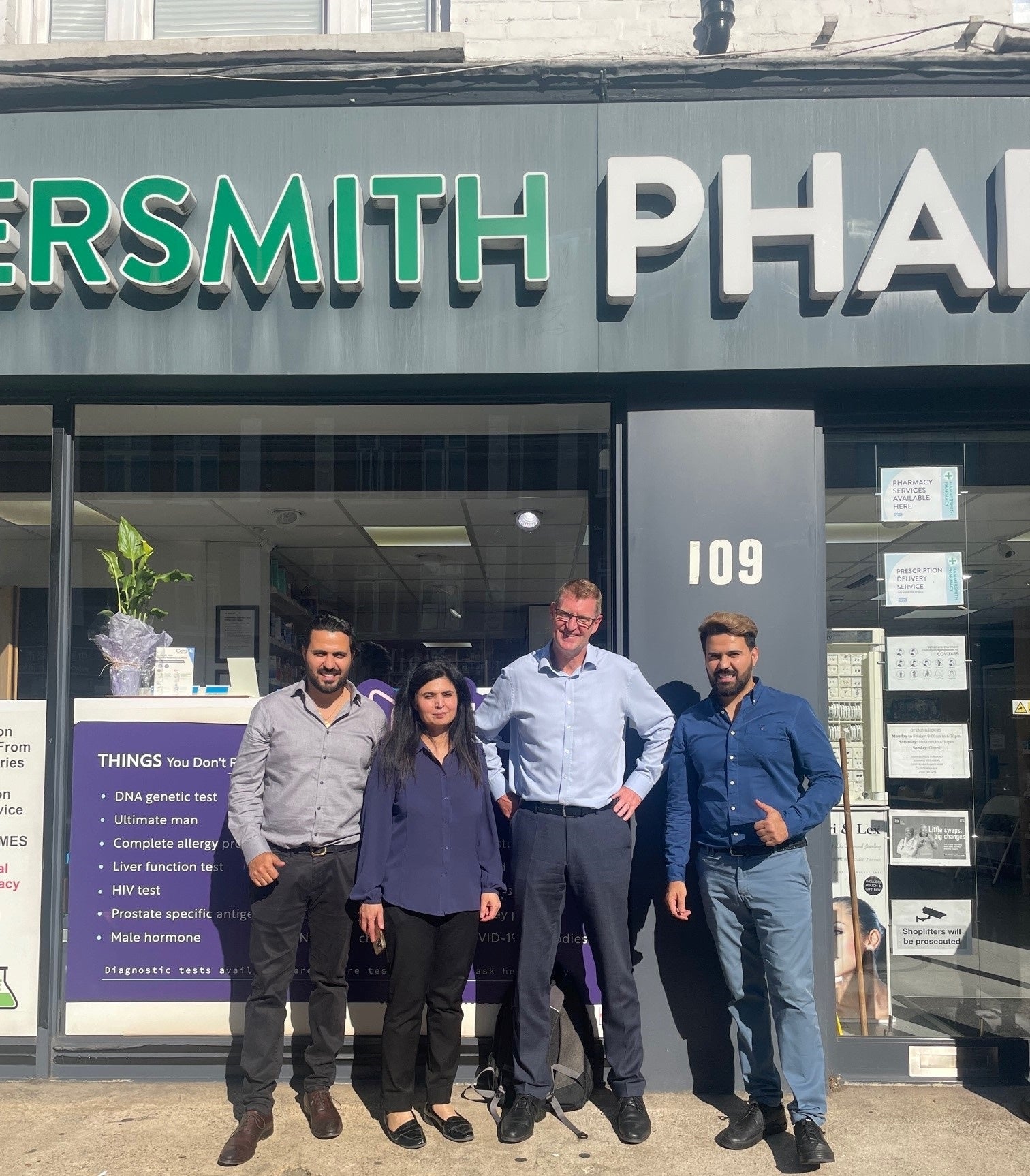 New owners standing in front of Hammersmith Pharmacy in West London, with their broker, Mark Page