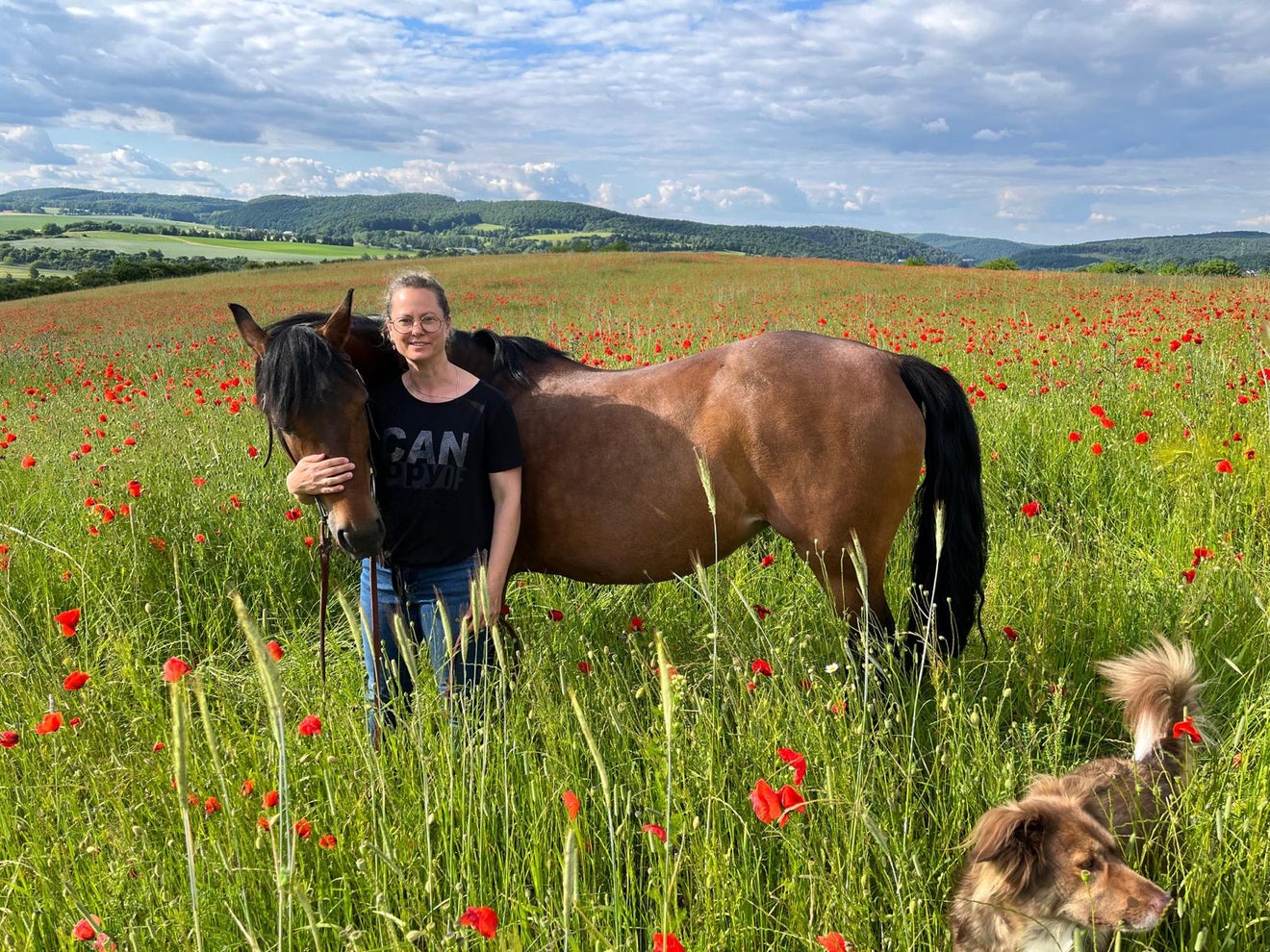 Auf dem Foto ist Diana mit ihrem Pferd auf einer Wiese abgebildet.