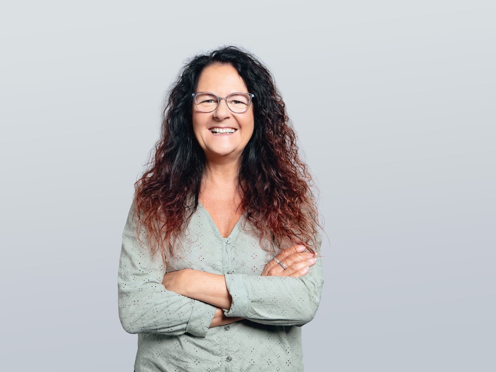 Frau mit langen lockigen Haaren lächelt in die Kamera Frau mit langen lockigen Haaren lächelt in die Kamera