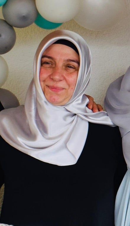 Eine Frau mit Kopftuch lächelt in die Kamera Eine Frau mit Kopftuch lächelt in die Kamera