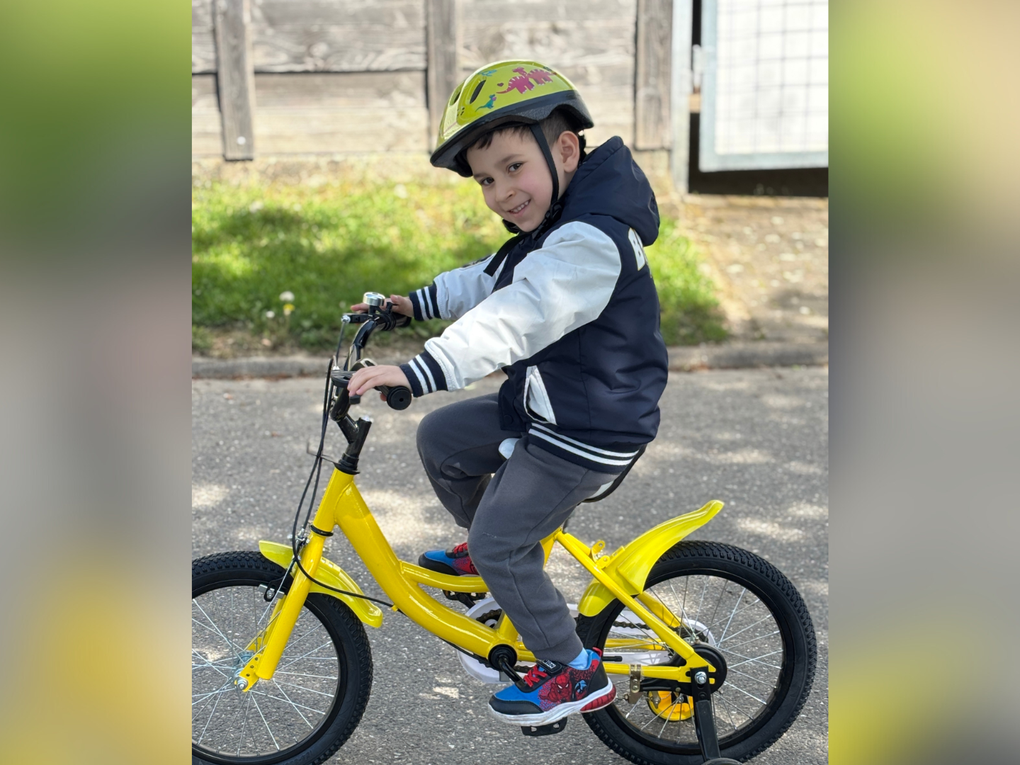 Ein Junge fährt ein gelbes Fahrrad Ein Junge fährt ein gelbes Fahrrad