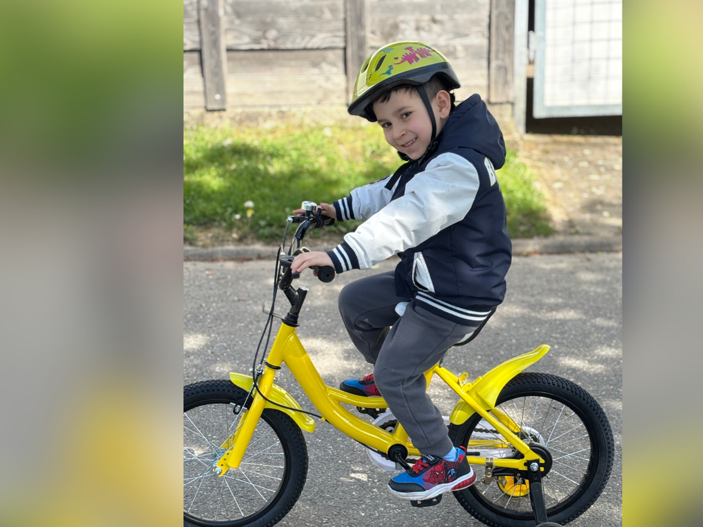 Ein Junge fährt ein gelbes Fahrrad Ein Junge fährt ein gelbes Fahrrad
