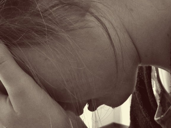 Nahaufnahme des Gesichts einer Frau. Sie beugt ihren Kopf nach unten und hält ihre Hände auf ihr Gesicht Nahaufnahme des Gesichts einer Frau. Sie beugt ihren Kopf nach unten und hält ihre Hände auf ihr Gesicht